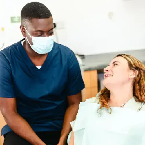 A patient smiling while a dentist prepares for a dental examination.